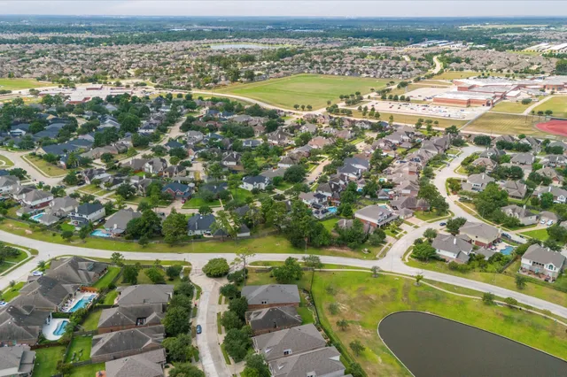 an aerial view of a residential houses with outdoor space and swimming pool