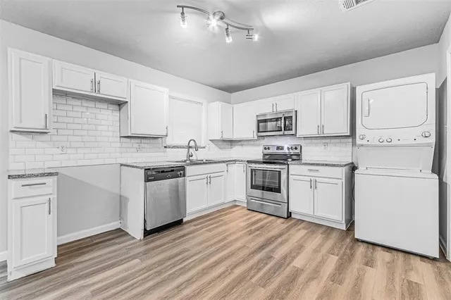 a kitchen with granite countertop white cabinets and white appliances
