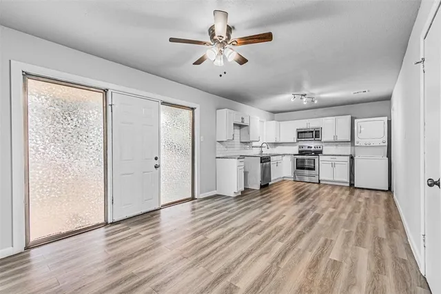 a view of kitchen with wooden floor electronic appliances and window