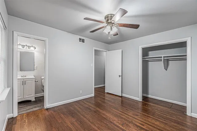 an empty room with wooden floor and mirror