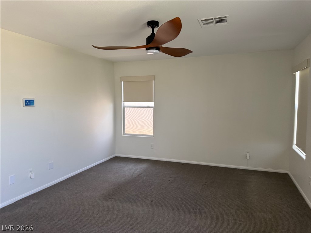 1141 Cathedral Ridge Street Henderson, NV 89052 - Photo 46 of 77 This spacious room features a ceiling fan, soft carpeting, and abundant natural light.
