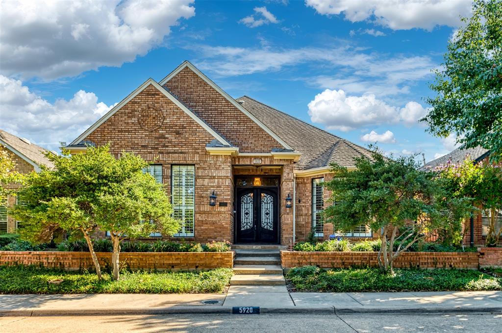 Brick exterior with a prominent gabled roofline and an arched double entry door