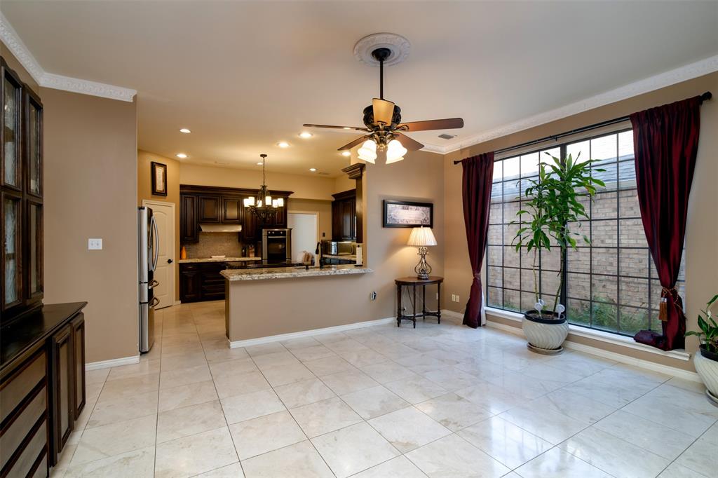 5920 Encore Drive Dallas, TX 75240 - Photo 12 of 34 Open-concept living area featuring light-toned large format tile flooring, a multi-pane grid window, and a ceiling fan with integrated lighting