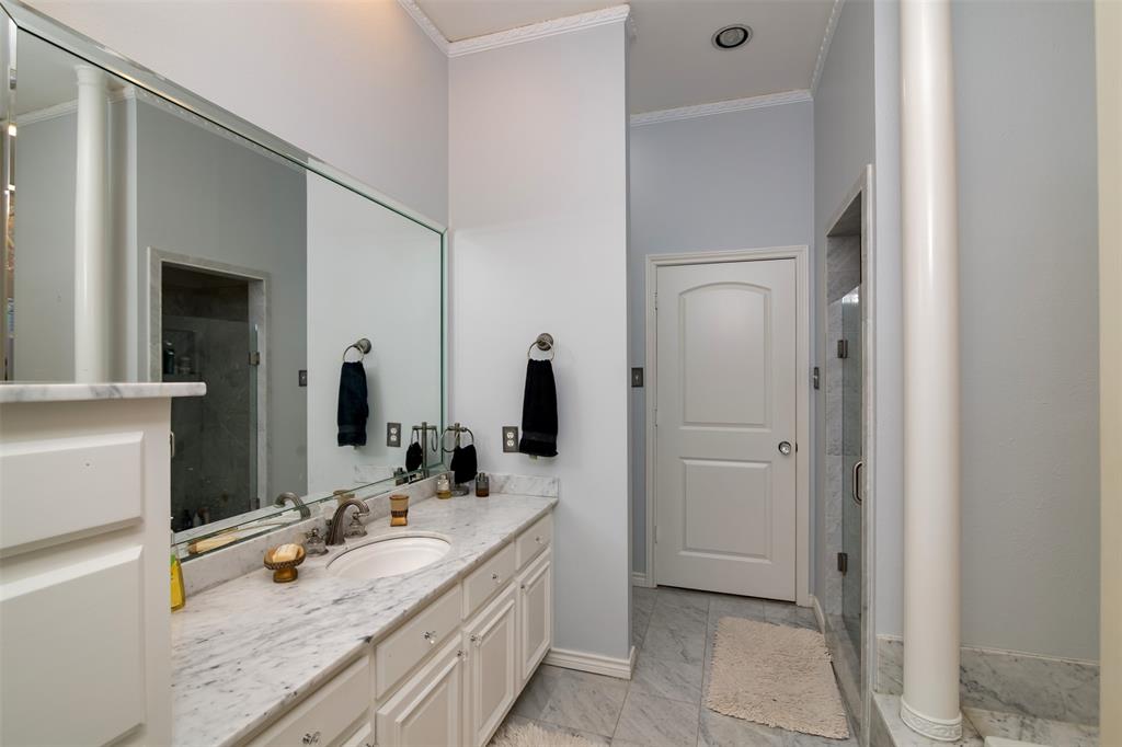 5920 Encore Drive Dallas, TX 75240 - Photo 18 of 34 Bathroom vanity featuring a light-colored countertop with an undermount sink and a large wall-mounted mirror