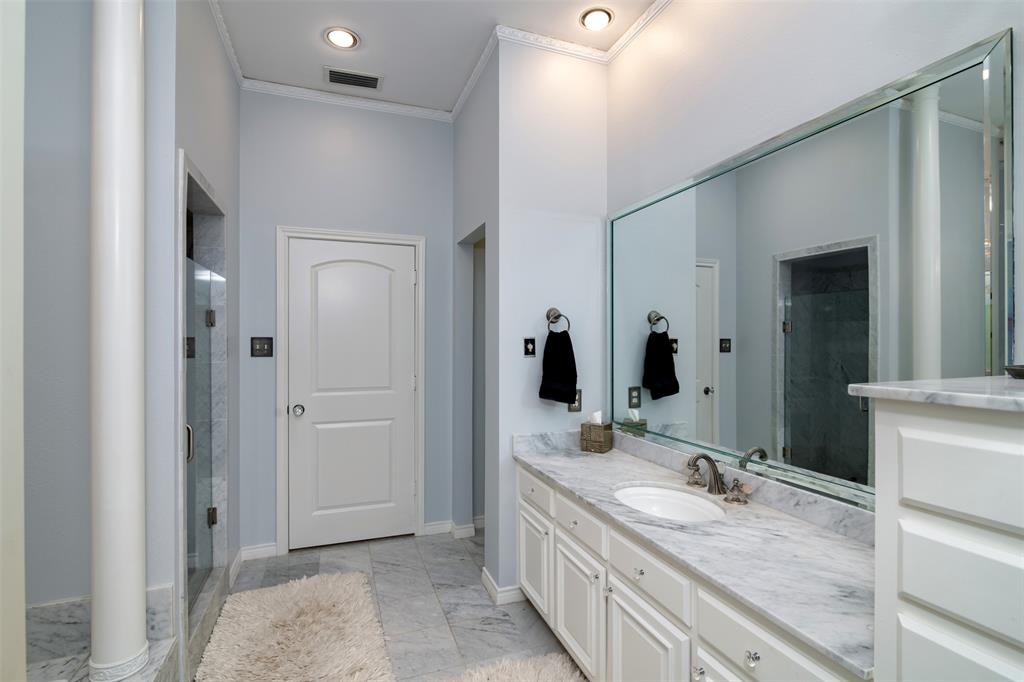 5920 Encore Drive Dallas, TX 75240 - Photo 19 of 34 Bathroom vanity featuring a single undermount sink, a stone countertop, and an expansive wall-mounted mirror