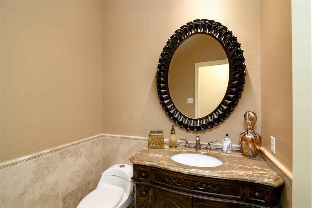 5920 Encore Drive Dallas, TX 75240 - Photo 23 of 34 Powder room featuring a carved wood vanity with an integral sink and a stone countertop