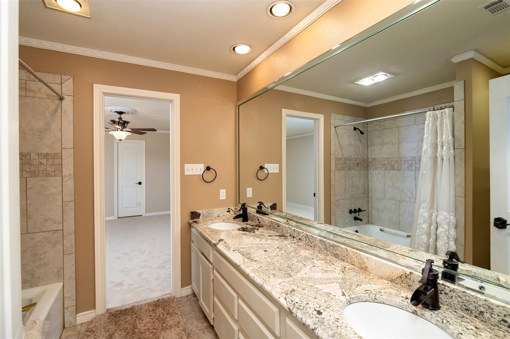 5920 Encore Drive Dallas, TX 75240 - Photo 27 of 34 Bathroom featuring a dual vanity with a granite countertop, white under-mount sinks, and oil-rubbed bronze fixtures