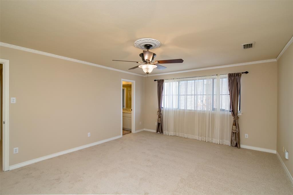 5920 Encore Drive Dallas, TX 75240 - Photo 29 of 34 Spacious carpeted room featuring a ceiling fan with decorative medallion, crown molding, and a large window with sheers and drapes