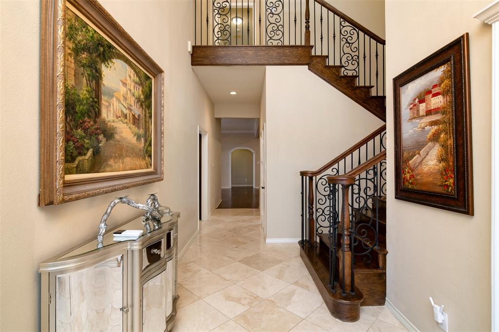 5920 Encore Drive Dallas, TX 75240 - Photo 8 of 34 Foyer featuring a grand staircase with dark wood-finish treads and risers, ornate wrought iron balusters, and a matching wood-finish handrail