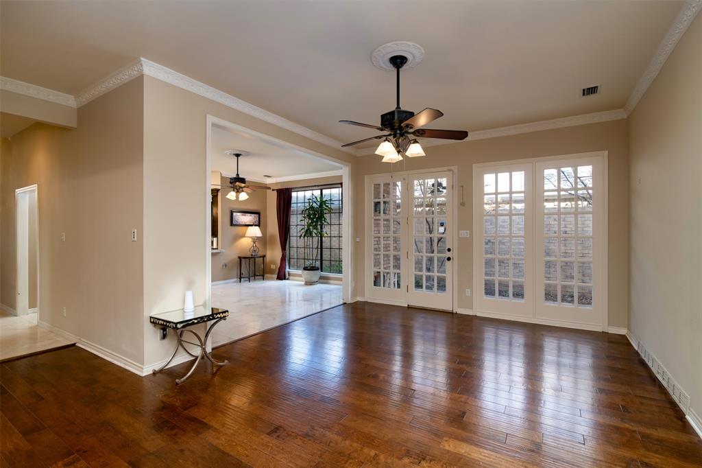 5920 Encore Drive Dallas, TX 75240 - Photo 10 of 34 Wood-finish flooring throughout, featuring a ceiling fan with integrated lighting, and crown molding