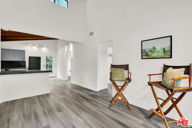 a view of a hallway with wooden floor and dining room view