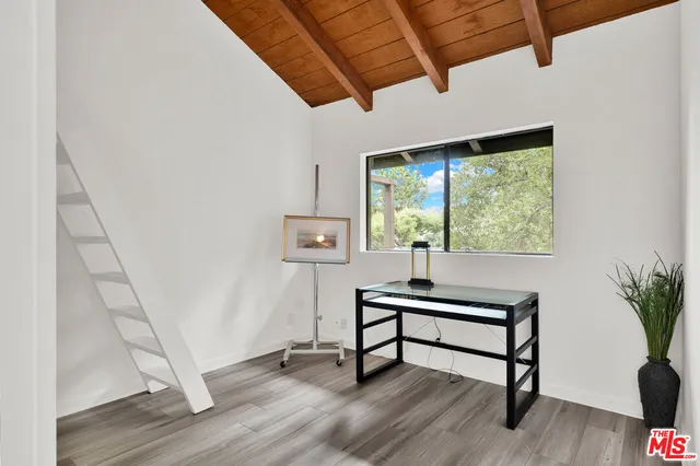 a view of a workspace with furniture and a window