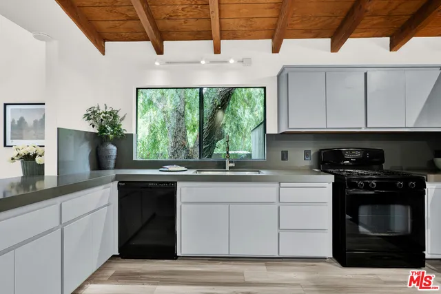 a kitchen with stainless steel appliances granite countertop a sink a stove and a microwave