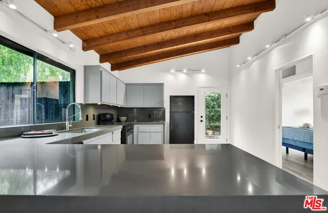 a kitchen with stainless steel appliances granite countertop a sink a stove and a refrigerator