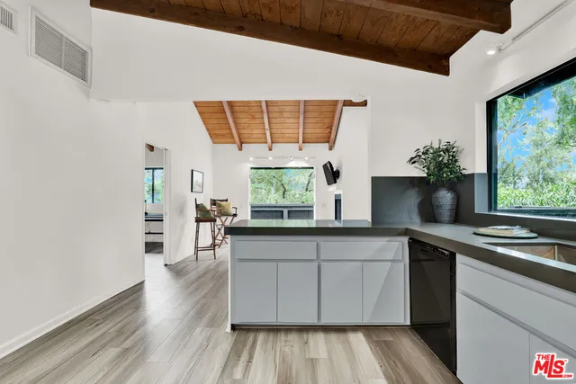 a kitchen with stainless steel appliances granite countertop a stove a sink and a large window