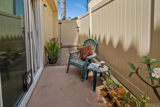 a view of a balcony with chairs and a potted plant