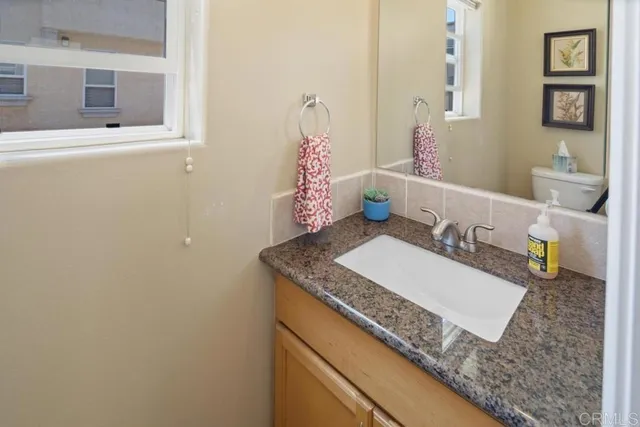 a bathroom with a granite countertop sink and a mirror
