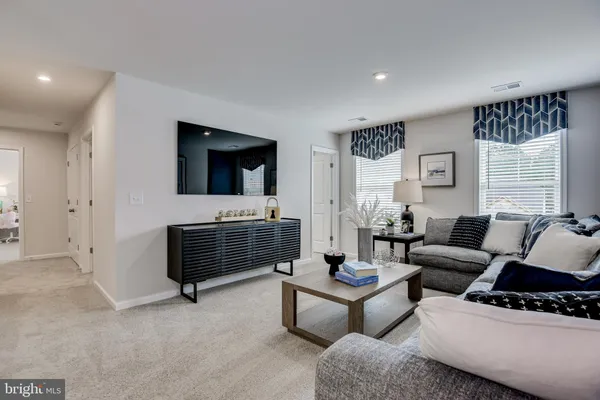 a kitchen with kitchen island a dining table chairs stainless steel appliances and cabinets