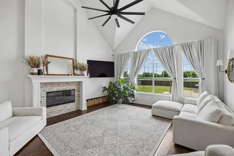 a living room with furniture a fireplace and a floor to ceiling window