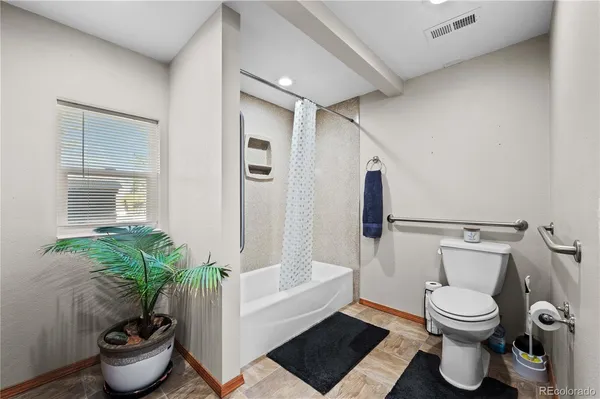 a bathroom with a toilet and a potted plant