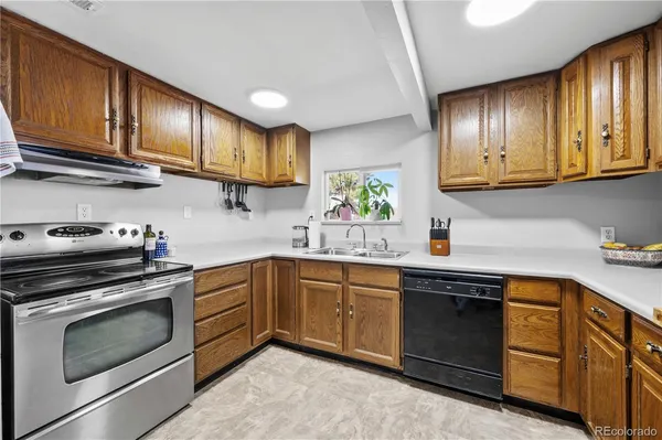 a kitchen with granite countertop wooden cabinets stainless steel appliances and a sink