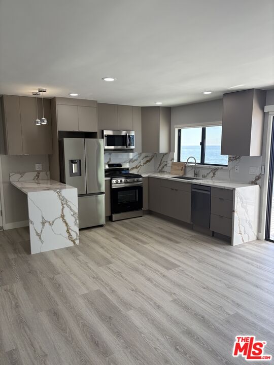 25216 1/2 Malibu Road Malibu, CA 90265 - Photo 3 of 6 a large kitchen with stainless steel appliances kitchen island granite countertop a sink and cabinets