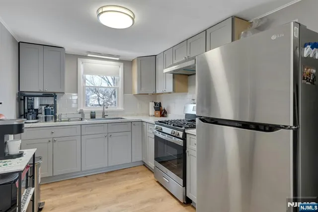 a kitchen with a refrigerator a sink and cabinets