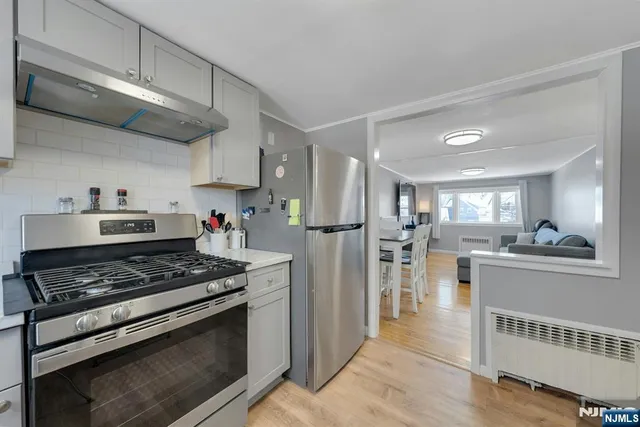 a kitchen with stainless steel appliances granite countertop a stove refrigerator and cabinets