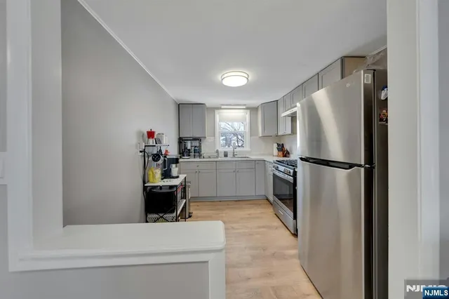 a kitchen with a refrigerator sink and white cabinets