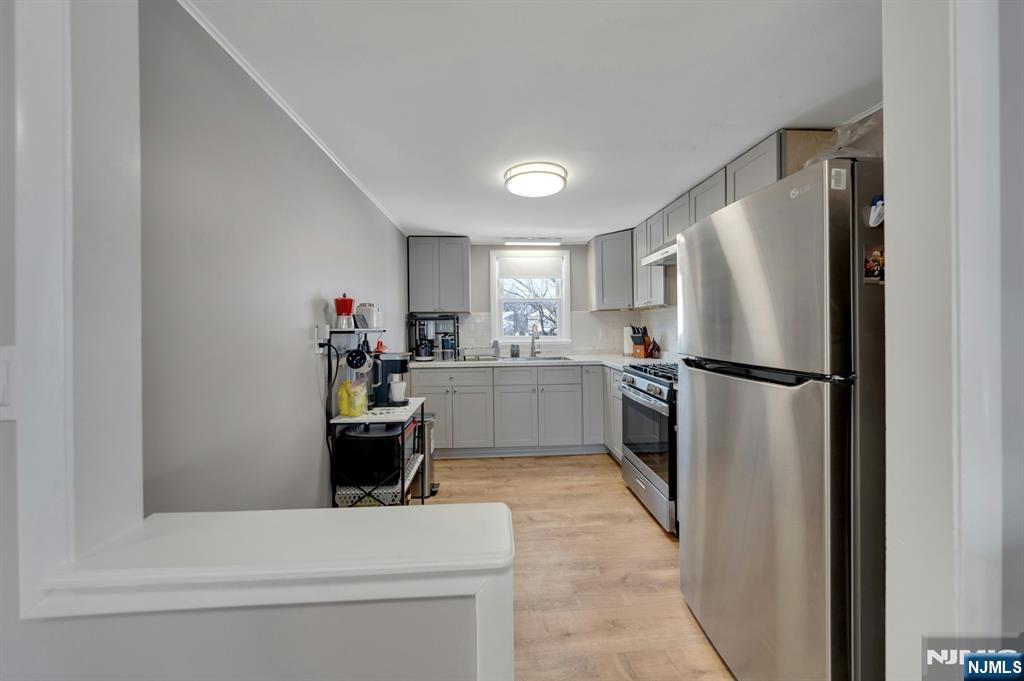61 Christina Street, Unit 2 Little Ferry, NJ 07643 - Photo 6 of 18 a kitchen with a refrigerator sink and white cabinets
