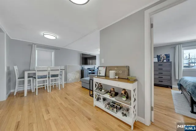 a living room with furniture a flat screen tv and a wooden floor