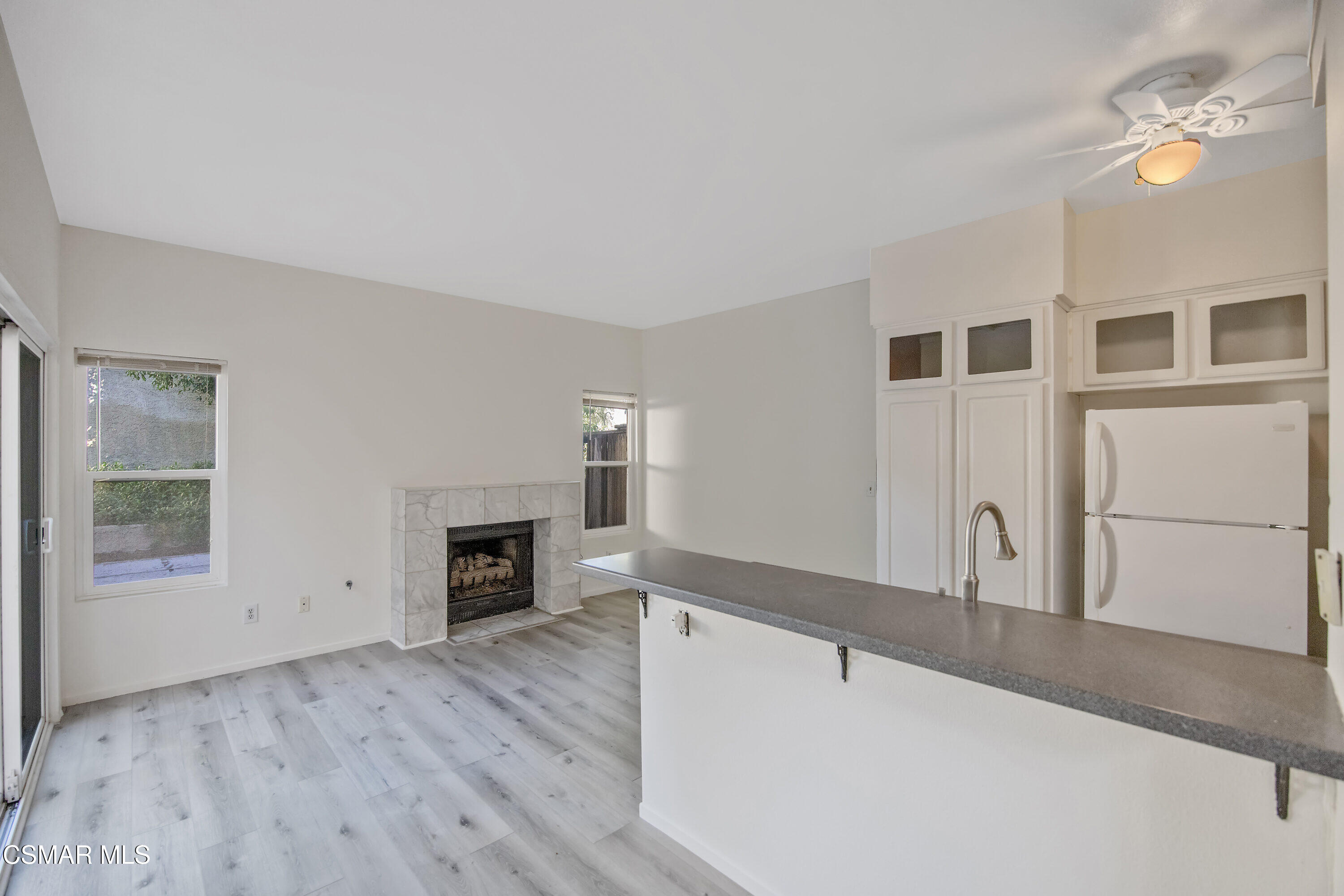11833 Nightingale Street Moorpark, CA 93021 - Photo 5 of 46 a view of a livingroom with a fireplace a ceiling fan and wooden floor
