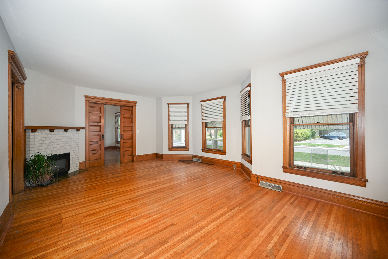 24021 Chicago Street Plainfield, IL 60544 - Photo 19 of 41 wooden floor fireplace and windows in an empty room
