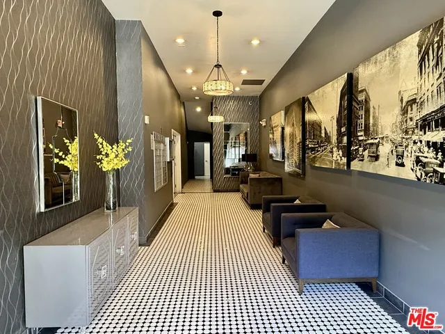 a kitchen with stainless steel appliances granite countertop a refrigerator a sink dishwasher a dining table and chairs with wooden floor