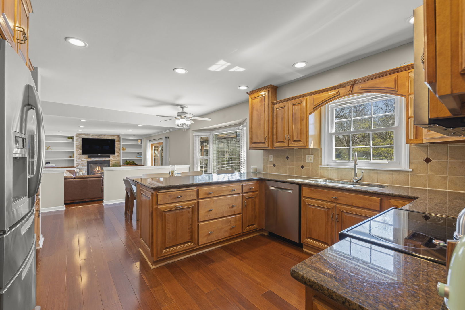472 Sheffield Road Naperville, IL 60565 - Photo 12 of 47 a kitchen with stainless steel appliances granite countertop wooden cabinets a sink dishwasher a stove and a refrigerator with wooden floor