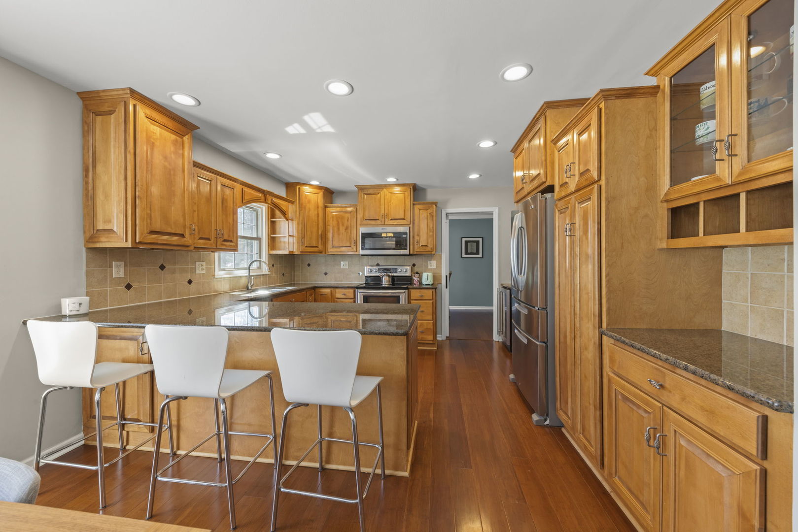 472 Sheffield Road Naperville, IL 60565 - Photo 10 of 47 a kitchen with stainless steel appliances kitchen island granite countertop a table chairs in it and wooden floors