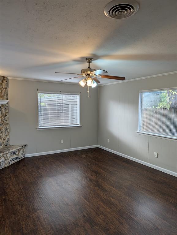 6324 Regal Road Forest Hill, TX 76119 - Photo 13 of 24 Empty room with dark wood-style flooring, ornamental molding, a textured ceiling, and ceiling fan