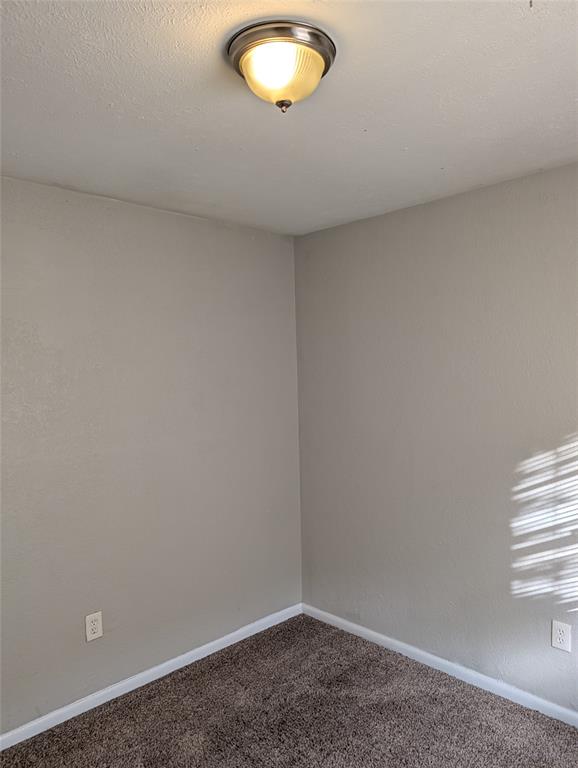 6324 Regal Road Forest Hill, TX 76119 - Photo 18 of 24 Carpeted spare room featuring baseboards and a textured ceiling