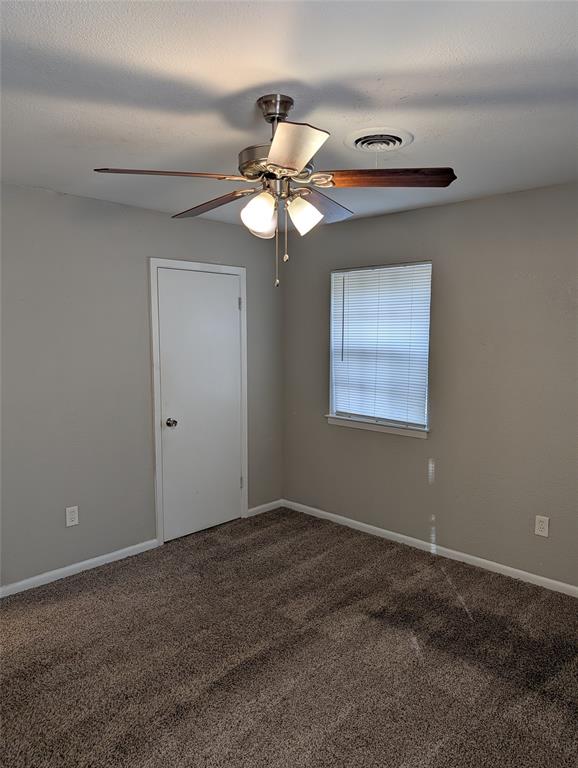 6324 Regal Road Forest Hill, TX 76119 - Photo 20 of 24 Unfurnished room with dark colored carpet and a ceiling fan