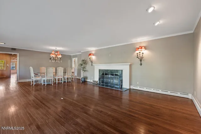 a view of a dining room with furniture a chandelier and wooden floor