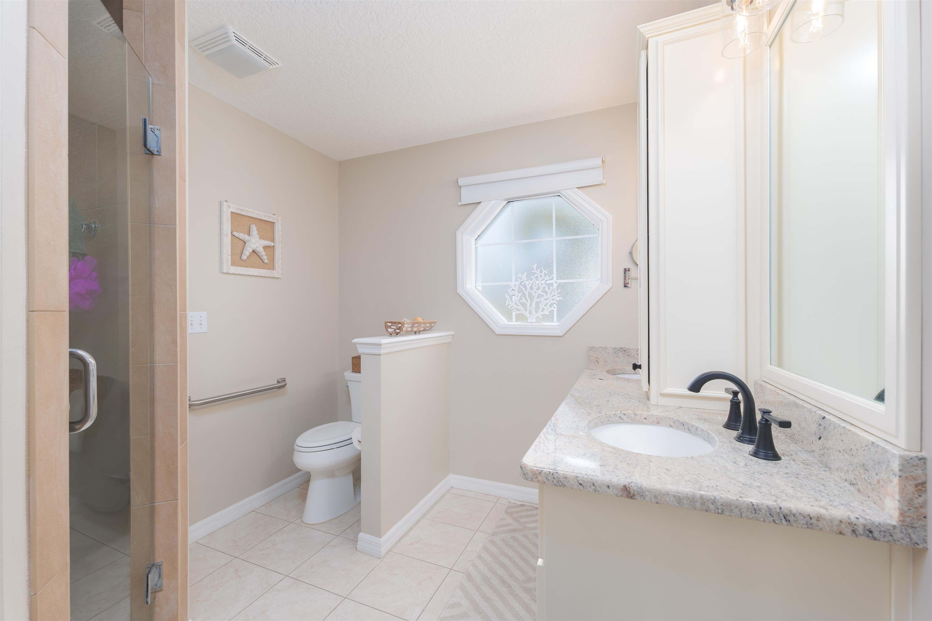 5324 5th Street St. Augustine, FL 32080 - Photo 27 of 45 a bathroom with a granite countertop toilet a sink and a mirror