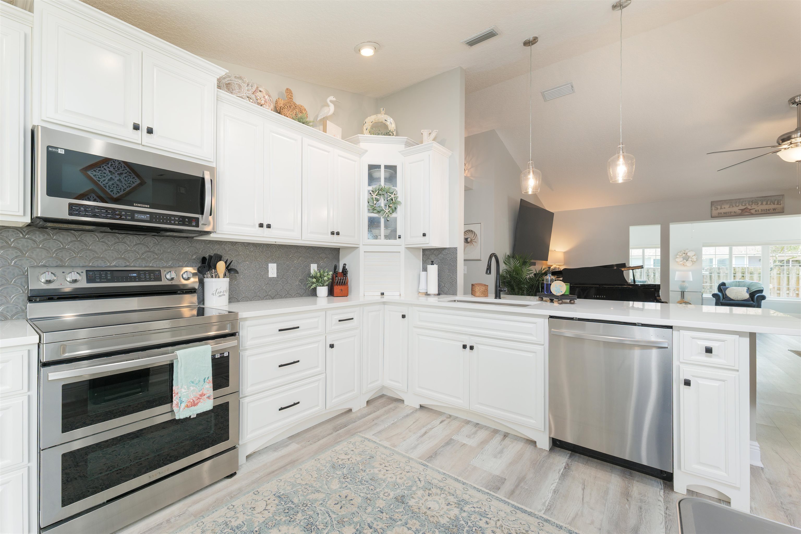 5324 5th Street St. Augustine, FL 32080 - Photo 35 of 45 a kitchen with granite countertop white cabinets white stainless steel appliances and sink