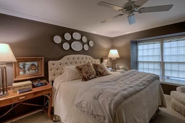 a bedroom with a bed and a flat tv screen on dresser