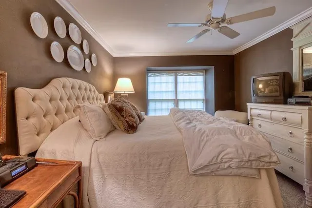 a bedroom with a bed and a flat tv screen on dresser