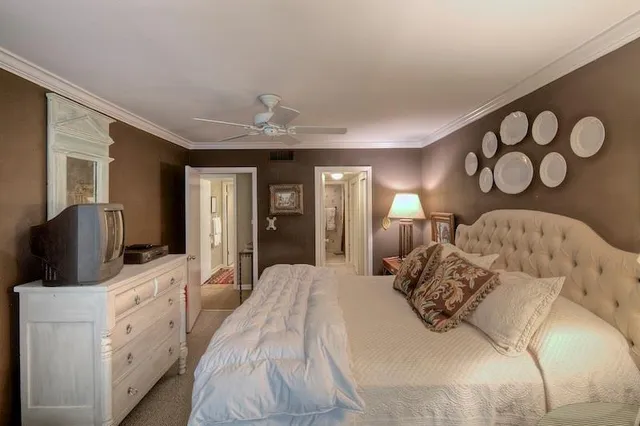 a bedroom with a large bed and a flat tv screen on dresser