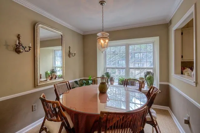 a dining room with furniture a chandelier and window