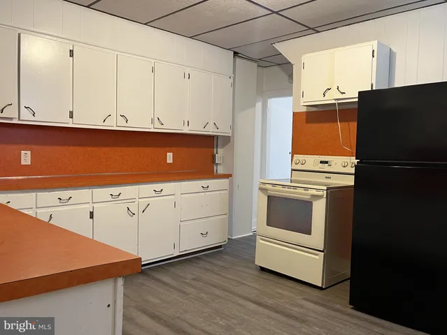 a kitchen with white cabinets and white appliances
