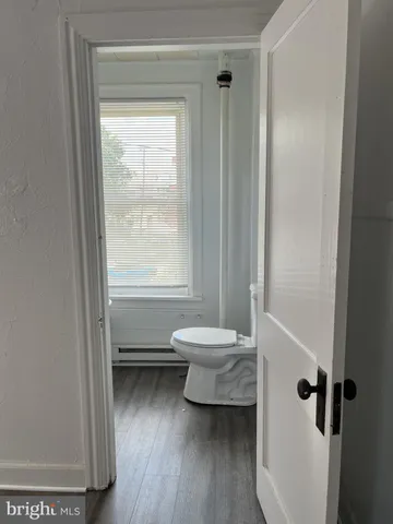 a bathroom with a window a toilet and a shower