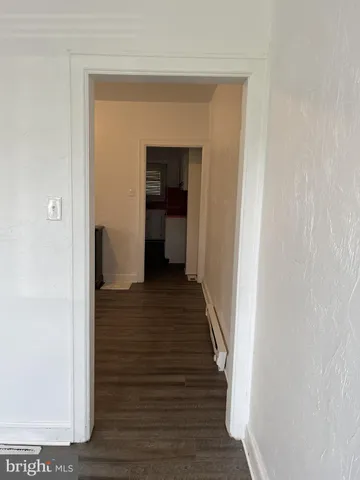 a view of a hallway with wooden floor and entryway