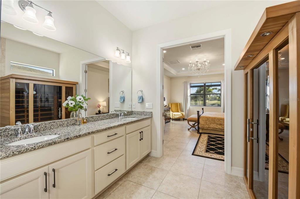 13349 Verandi Street Venice, FL 34293 - Photo 20 of 76 a spacious en suite bathroom with a granite countertop sink mirror and a bath tub